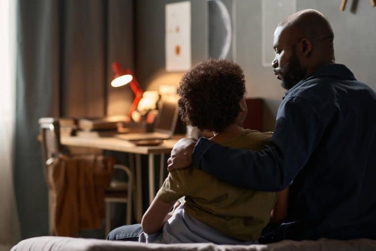 Parent consoling and listening to their child while having a conversation about bullying