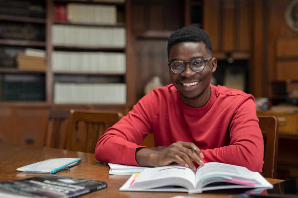 Happy university student in library
