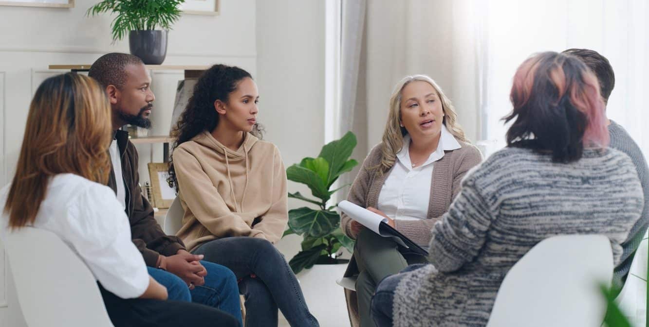 Counselling, group and psychology discussion with group of diverse people in therapy for addiction