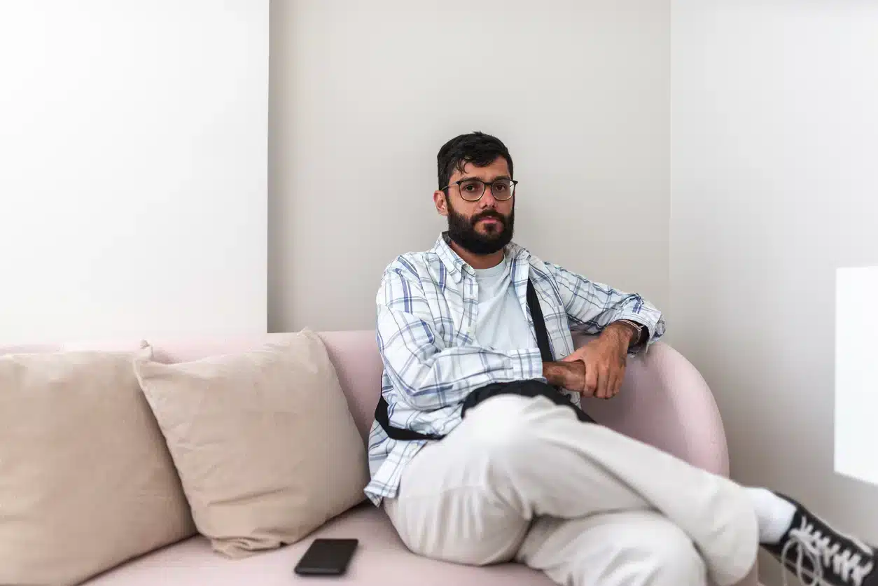 Non-binary adult with autism sitting on the couch