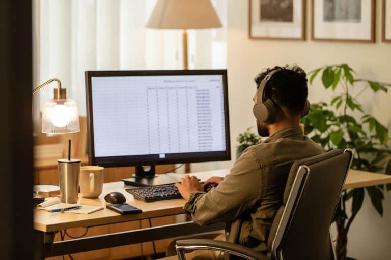 Young businessman looking at excel spreadsheet to analyse data and interpret it